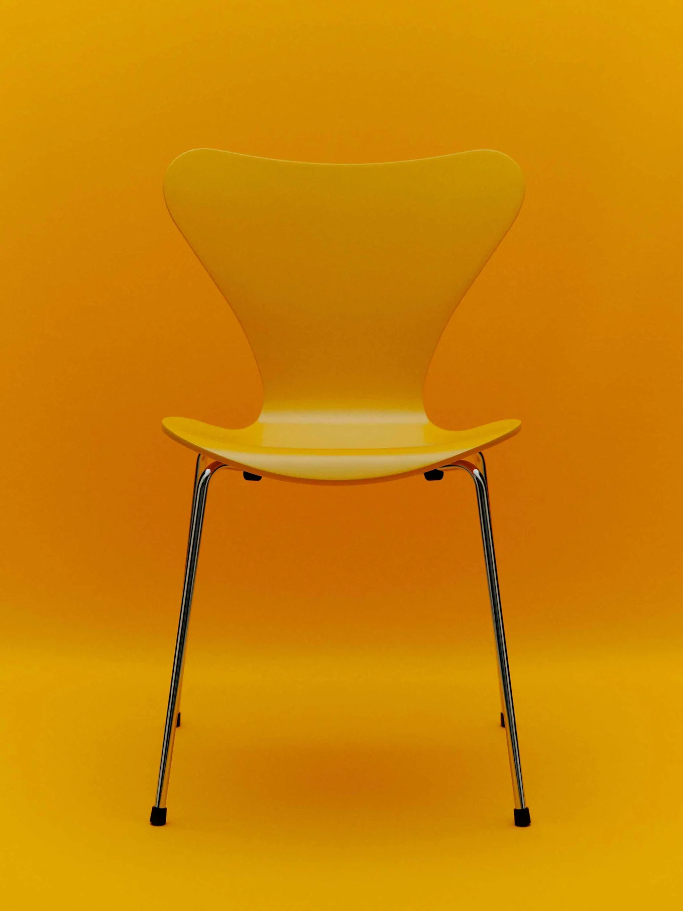 Gul stol med kromben mot en gul bakgrunn.