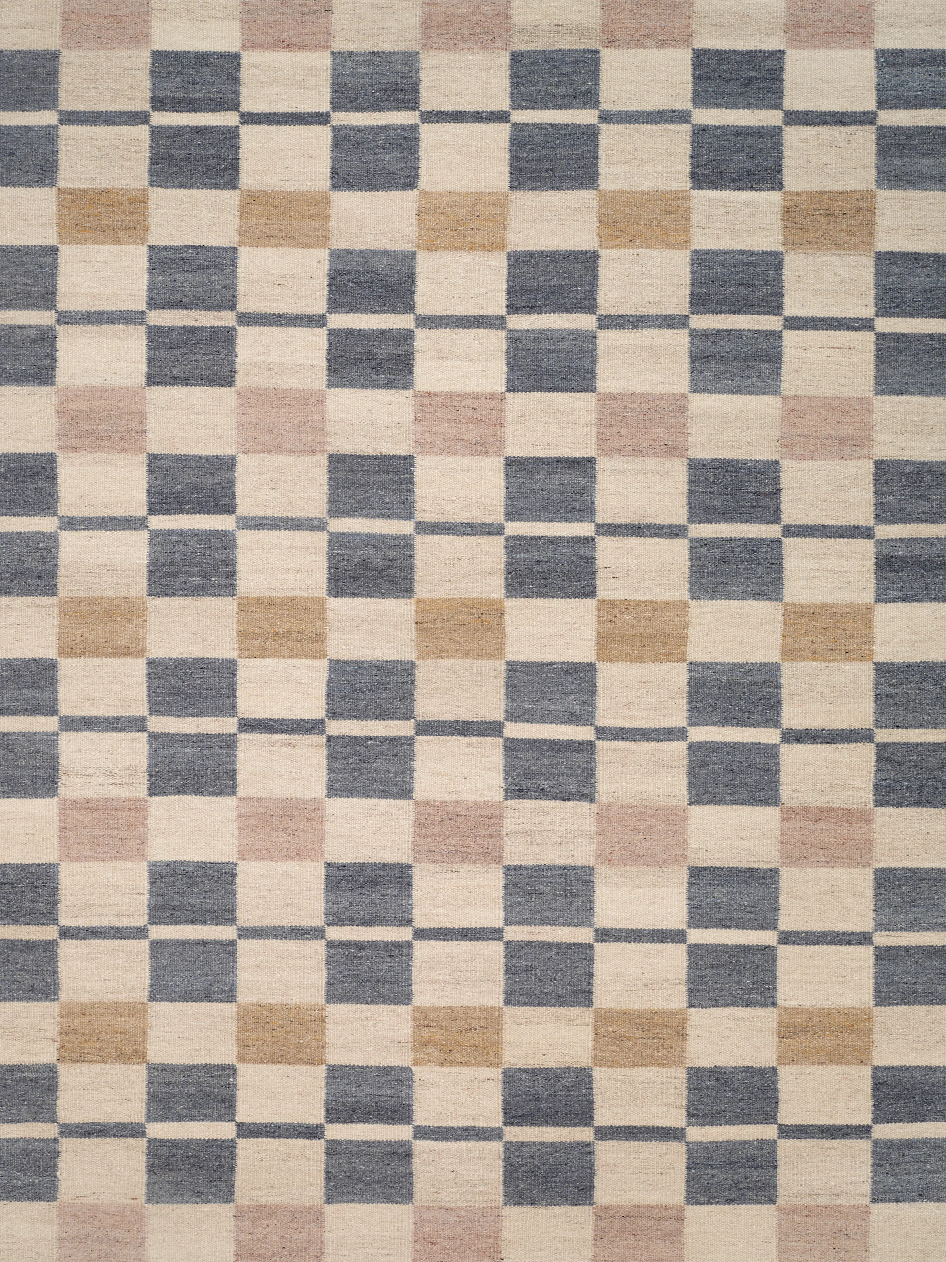 Rutete teppe i off-white, mørk gråblå, lys brun og lys rosa.