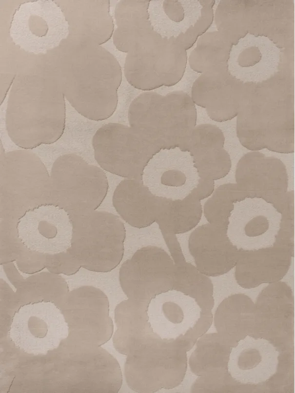Et rektangulært lys beige teppe med et opphøyd blomstermønster av store, stiliserte blomster.