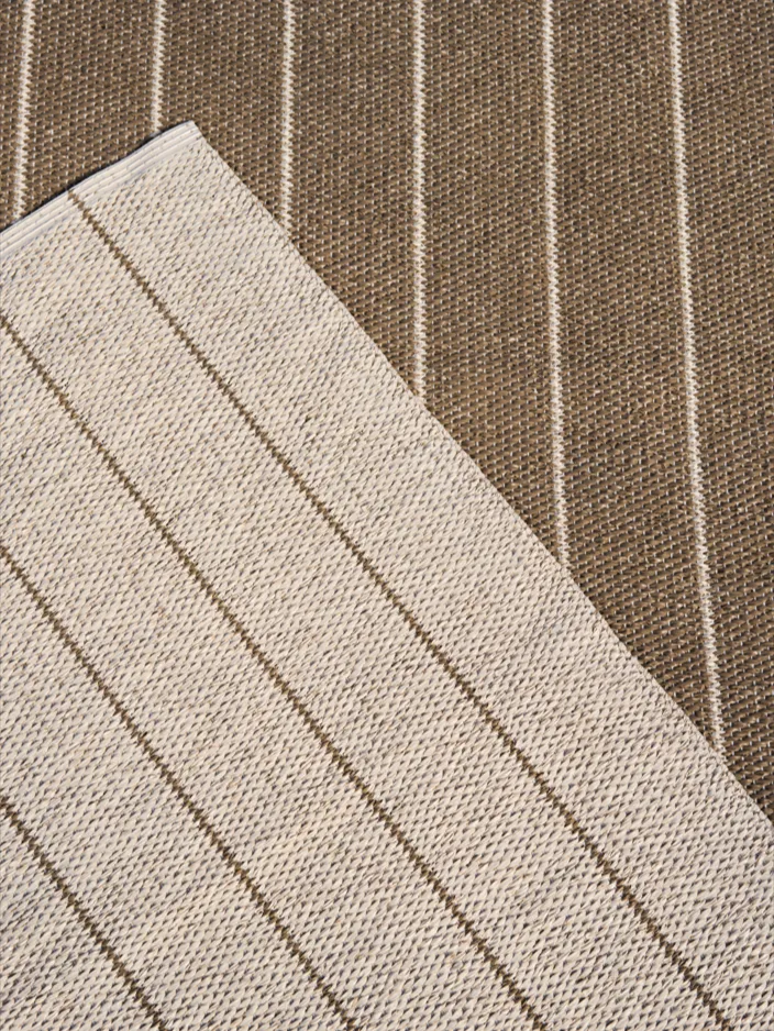 Stripete stoff i beige med brune striper, lagt diagonalt over brunt stoff med beige striper.