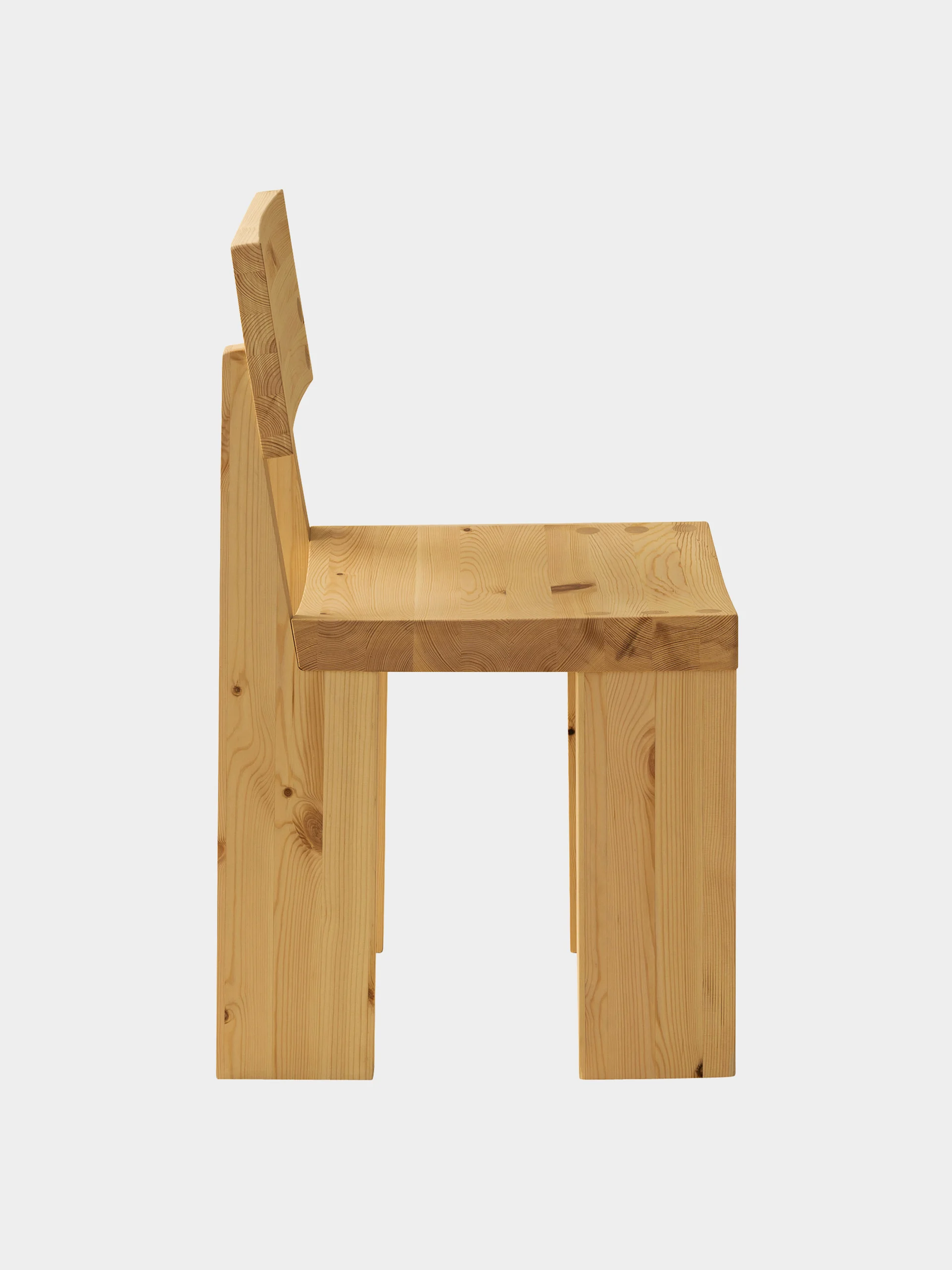 En minimalistisk trestol sett fra siden, med tykt, lyst tre med synlige årer og kvister.